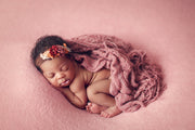 newborn baby girl with dark skin, pink ruffle layering wrap and posing fabric by custom photo props