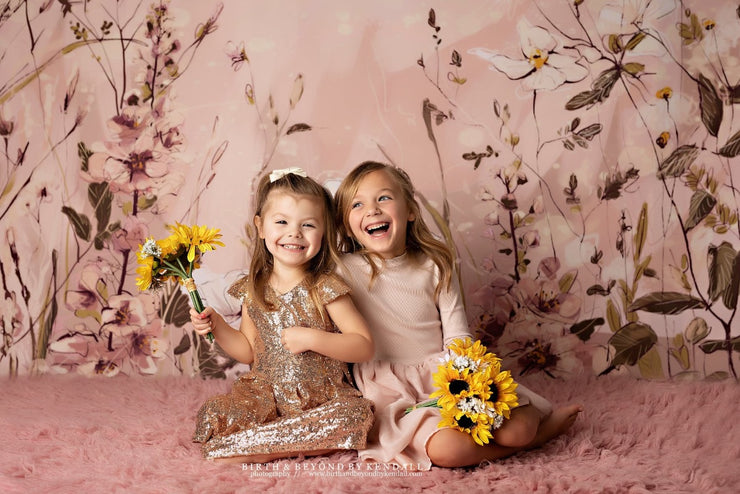 two happy girls smiling with pink flower backdrop and fur flooring by custom photo props
