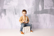 young boy on block with gray tones and white brush stroke photography backdrop by custom photo props