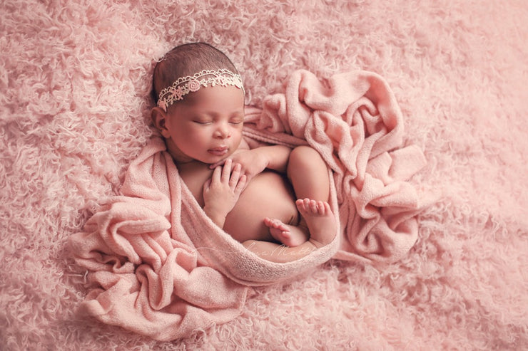newborn indian girl with pink faux fur and swaddling wrap by custom photo props