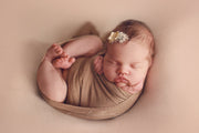 brown stretch swaddle wrap on newborn girl