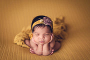 newborn girl in froggy pose with yellow and purple headband on striped yellow posing fabric by custom photo props