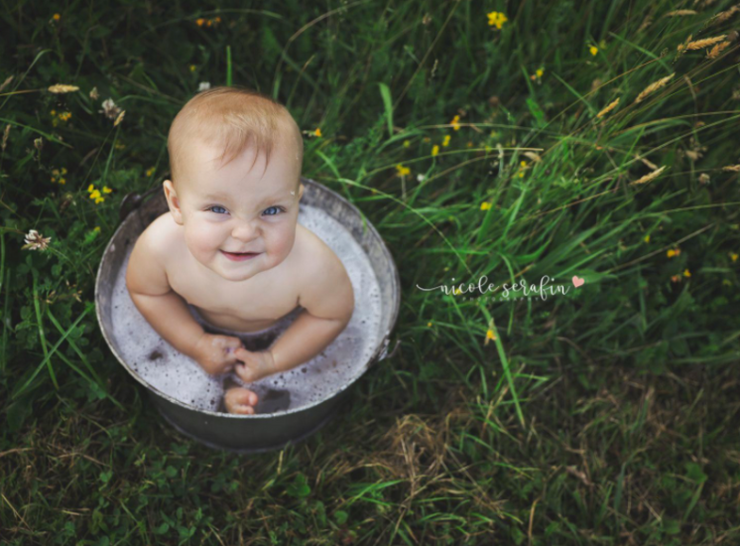galvanized pail with sitting baby in water with bubbles outside