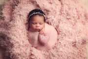 light pink, curly faux flokati fur with newborn girl swaddled in pink wrap and felted heart with dad on it