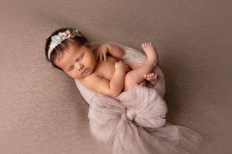newborn girl in large fabric bow for newborn pictures