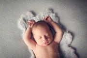 gray newborn baby posing with felted rabbit pelt