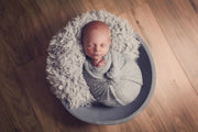 baby sleeping on soft light gray faux fur and wrapped in a gray mohair wrap photography prop