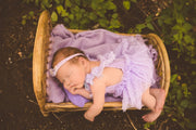 newborn girl hanging off miniature or small bamboo newborn bed photo prop