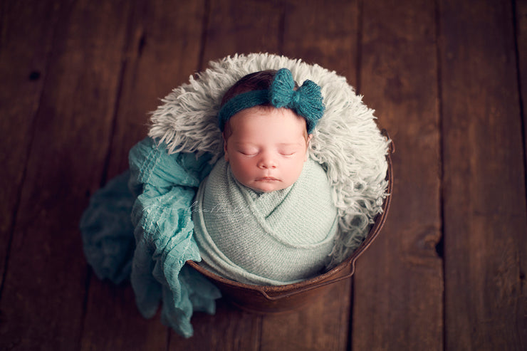 little girl in bucket with teal blue mohair bow, fur, ruffle layer and swaddling wrap