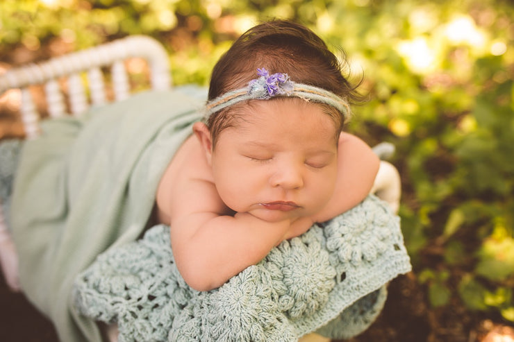 newborn baby with aqua blue layering blanket 