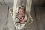 newborn baby girl in hanging macrame hammock for newborn photos