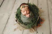 dark green faux fur and matching swaddling wrap and headband on newborn girl
