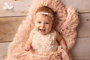 peach toned faux fur with 3 month old laying on it for baby photos