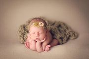 newborn baby girl headband with flower petal and hemp with moss. baby girl in froggy pose. 