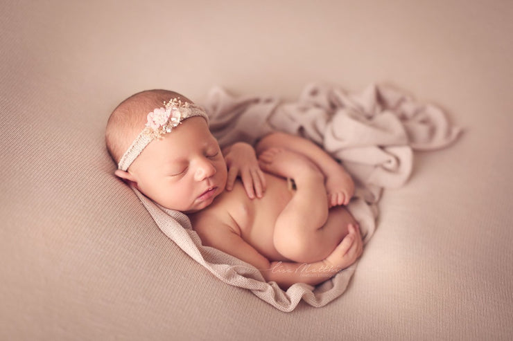 super soft pink stretch pink posing cloth for newborn poser with newborn girl and headband, back posed