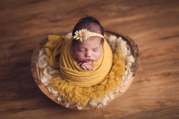 newborn girl with yellow headband, faux flokati fur and fuzzy swaddling wrap