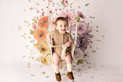 girl in swing with flower backdrop in circle