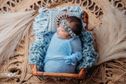 newborn baby boy or girl in basket with rug and chunky layer with blue mohair wrap