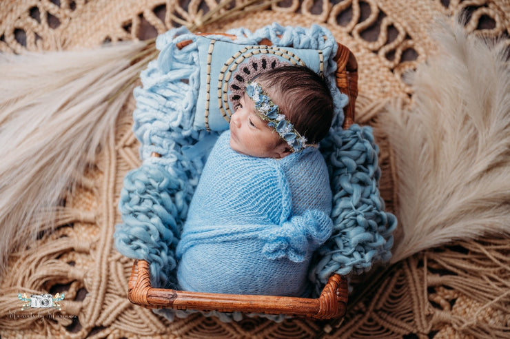 newborn girl with chunky newborn baby blanket in blue stylized set with bohemian motif