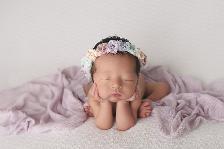 light purple baby wrap and newborn girl wearing matching halo in rainbow colors